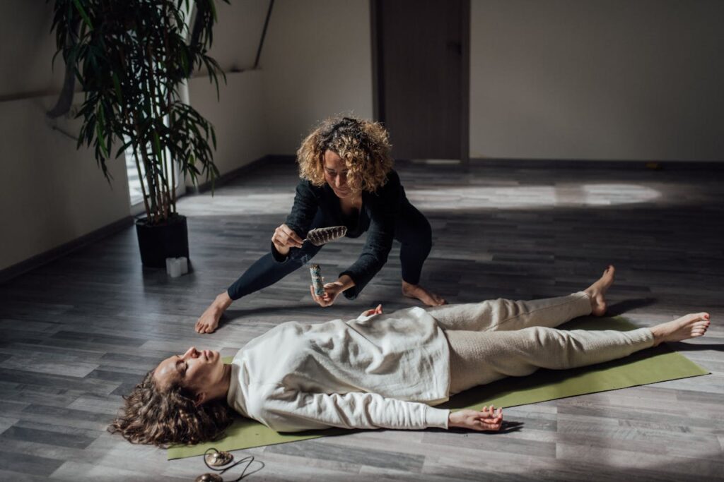 A reiki healer uses white sage in a calming indoor setting for a spiritual healing ritual.