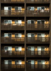 Symmetrical view of a modern apartment facade featuring multiple balconies and windows.